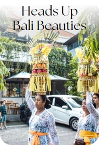 Bali women carry Balinese offerings on their head in the front of Bali Direct Store